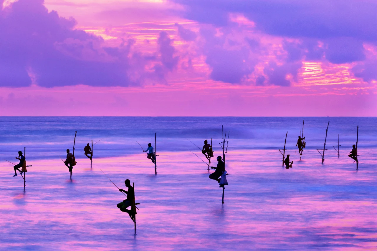 Sri Lanka Tour Package Fishermen on stilts in silhouette, Sri Lanka